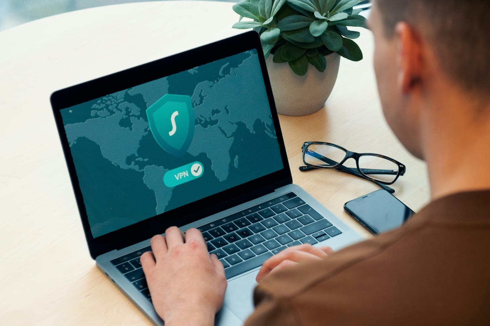Personne devant un ordinateur portable affichant une connexion sécurisée par réseau privé virtuel.