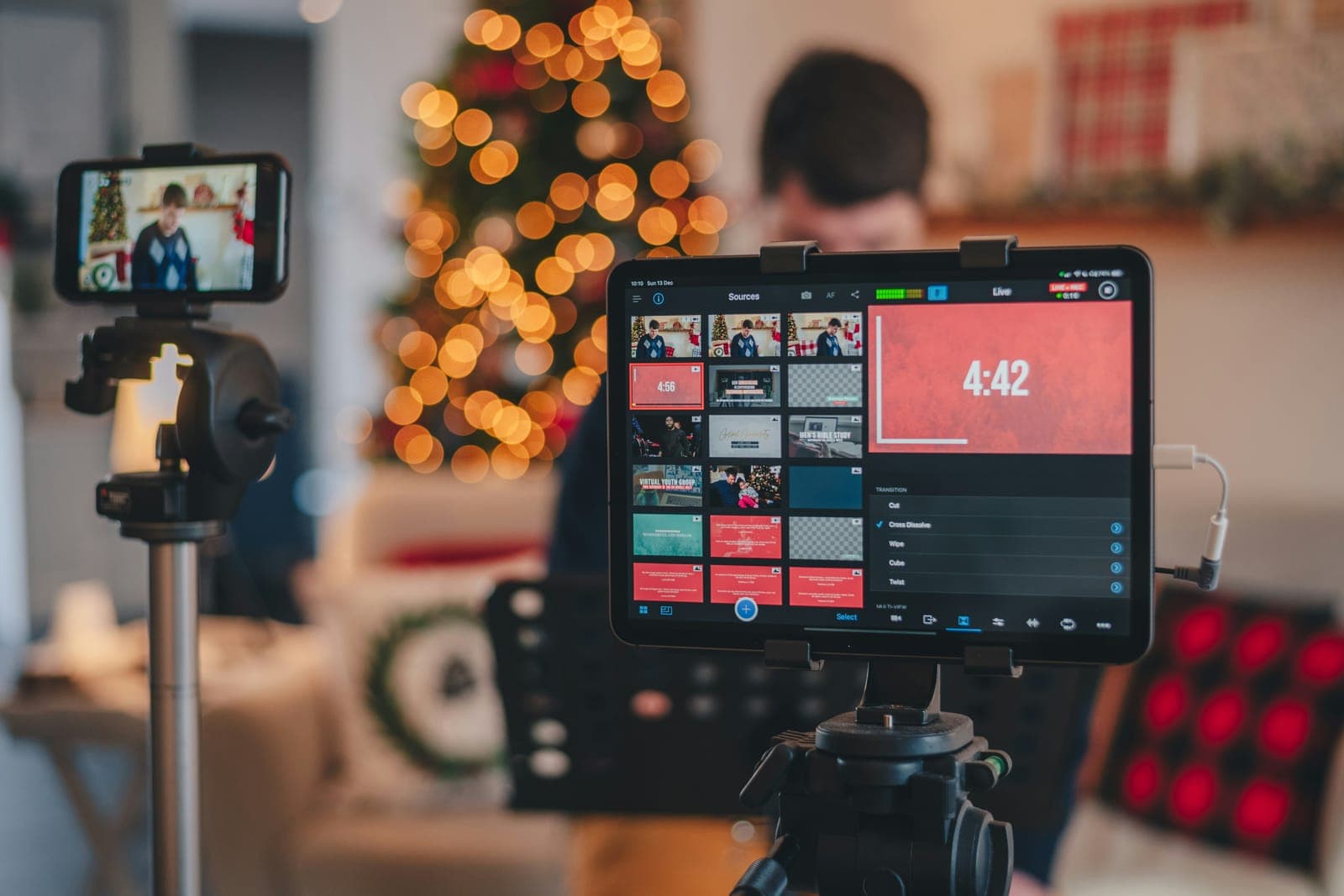 Régie de diffusion en direct : tablette de mixage, caméra sur trépied et sources vidéo.