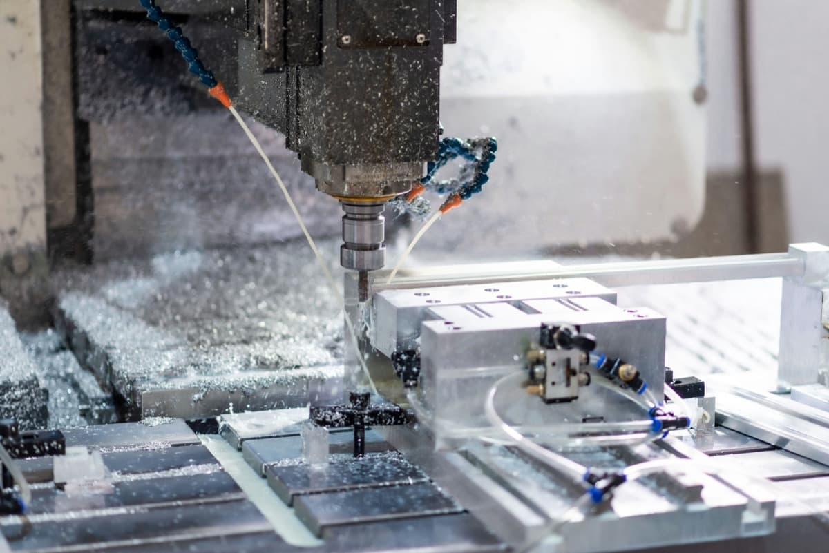 Centre d'usinage à commande numérique en cours de coupe dans un atelier de fabrication.